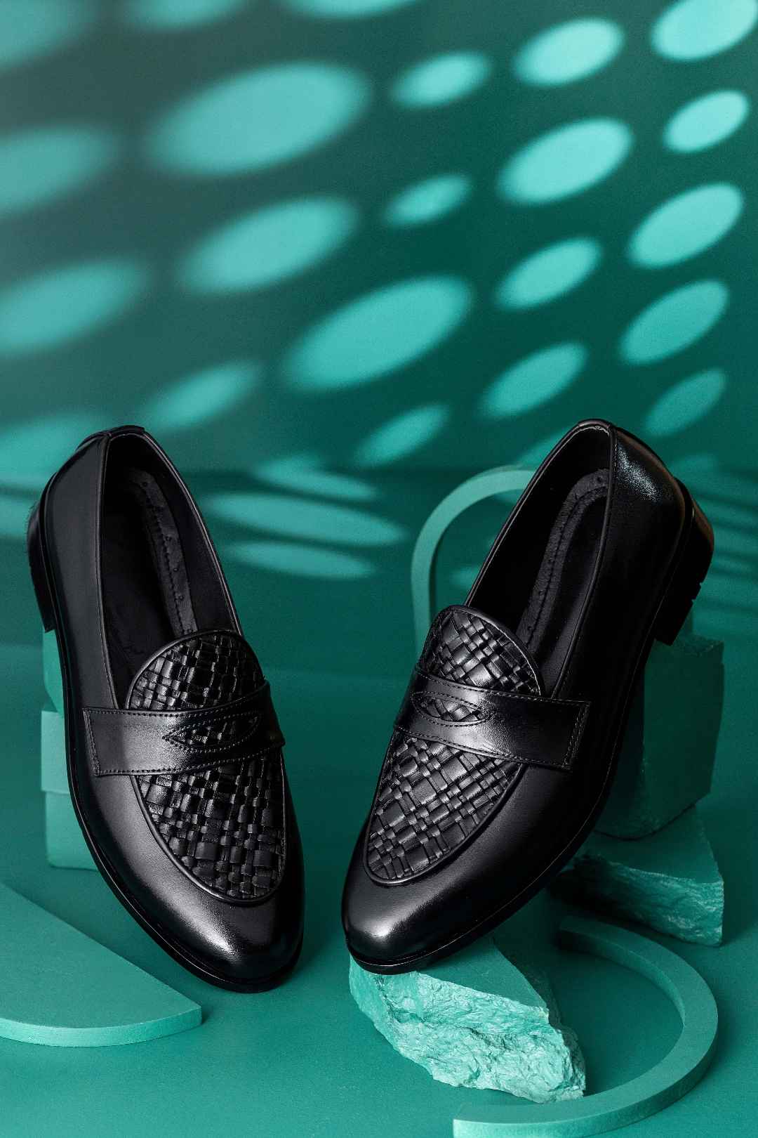 black formal shoes studio shot teal background