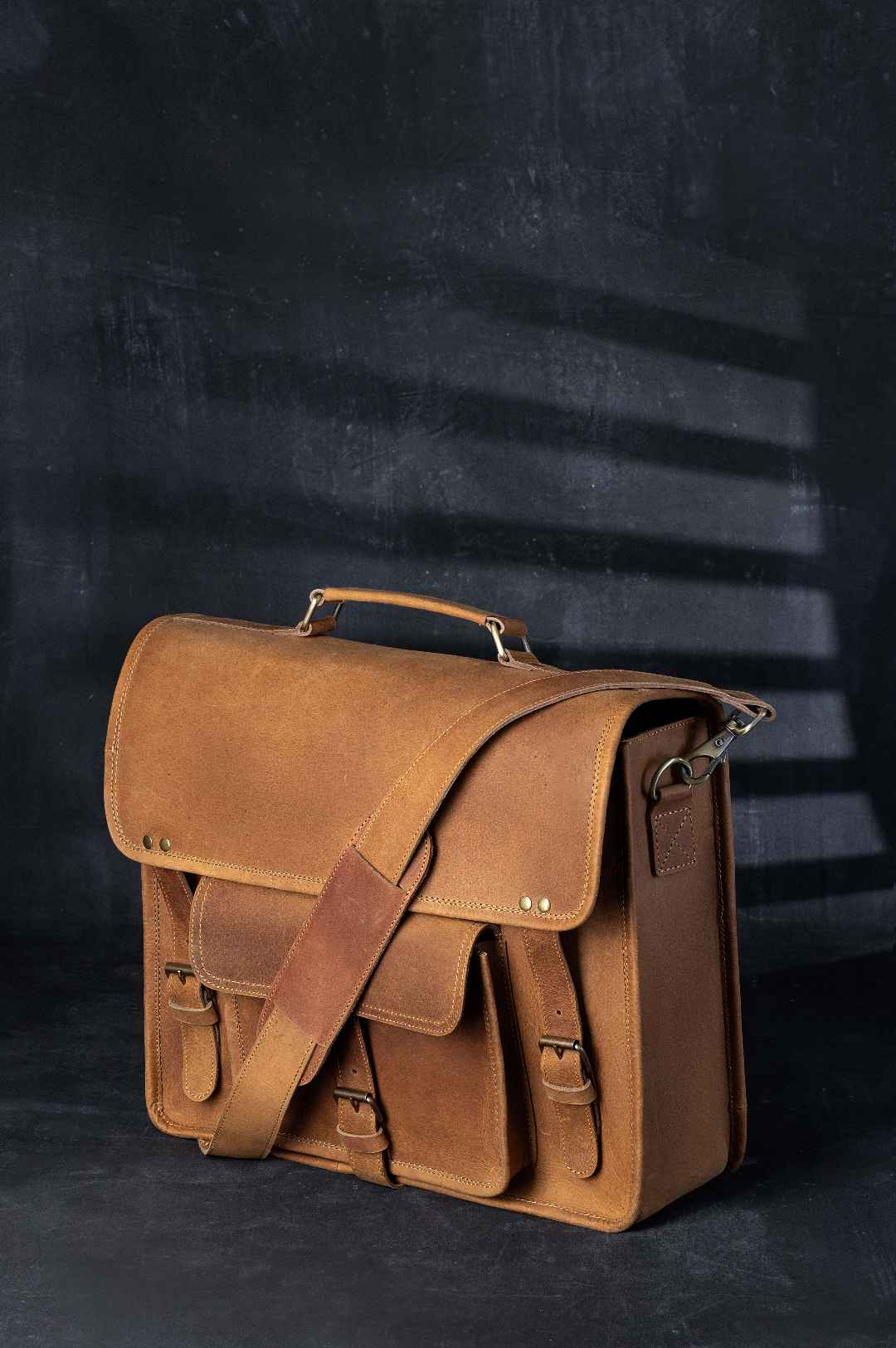 brown leather laptop bag studio photography dark gray background