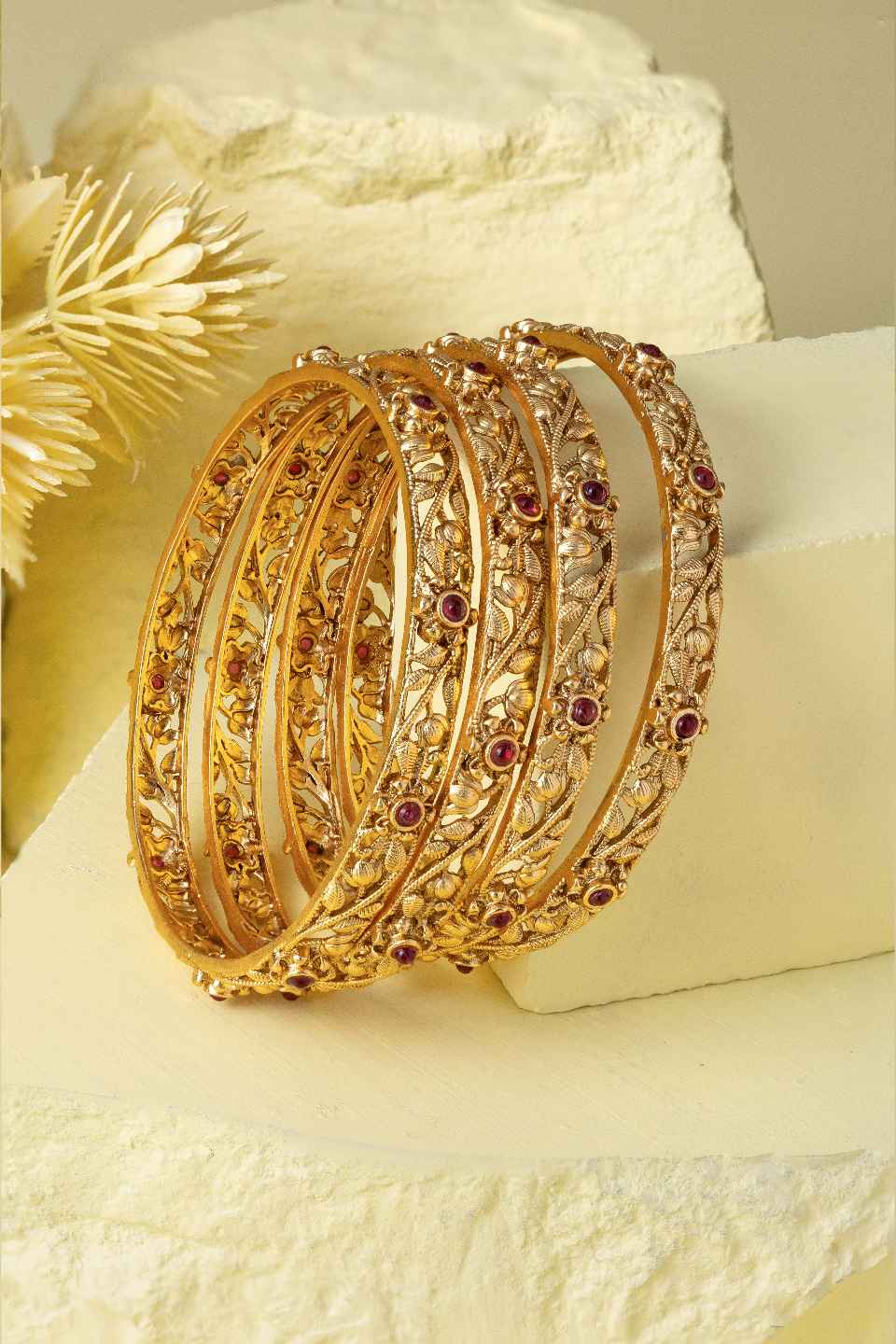 Gold filigree bangles creative shoot on yellow background