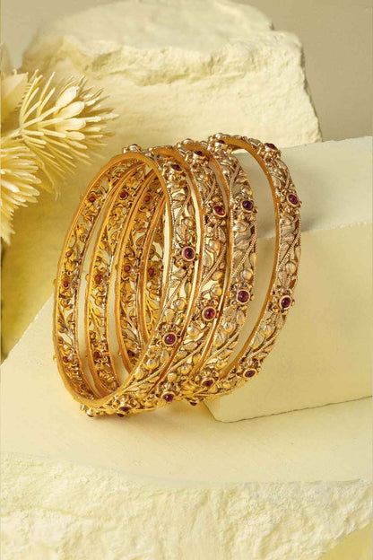 Gold filigree bangles creative shoot on yellow background
