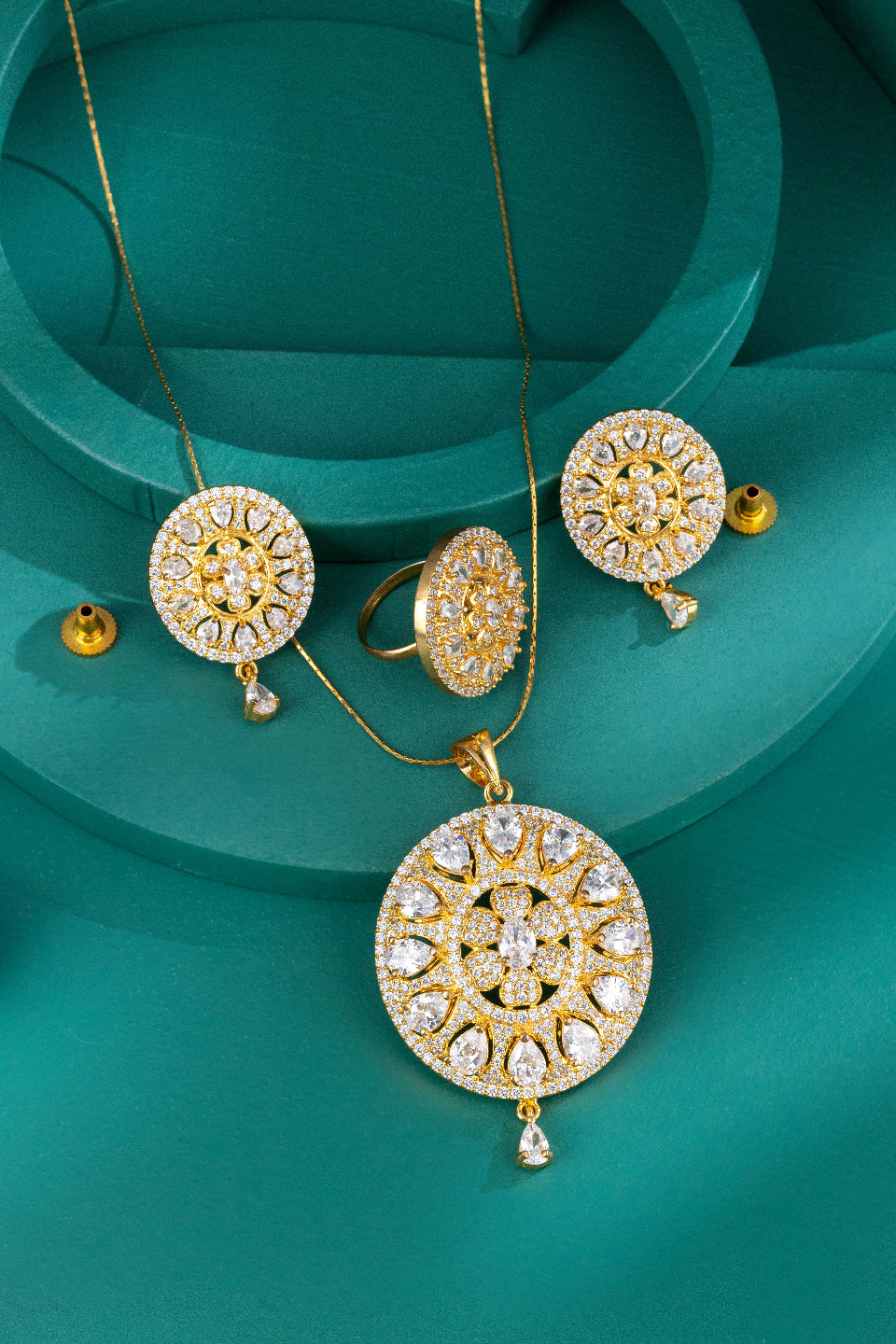 gold pendant necklace set product shoot green background