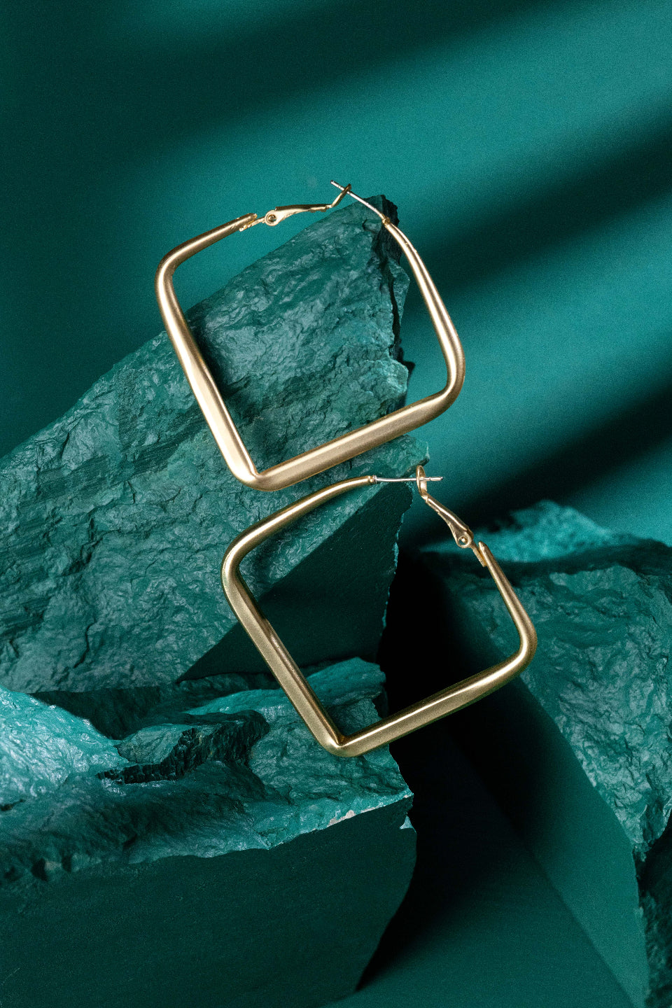 gold square hoop earrings photography green background
