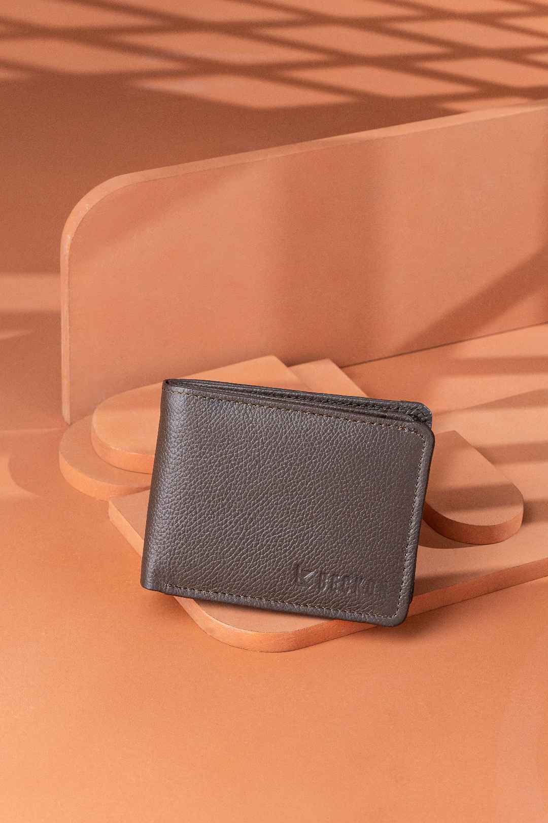 leather wallet creative podium style shoot on pale copper background